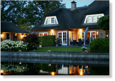 Woning aan het water, met verlichte steiger. Watervilla. Tuinverlichting. Led bolders.