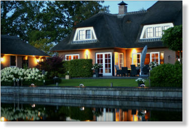 Woning aan het water, met verlichte steiger. Watervilla. Tuinverlichting. Led bolders.