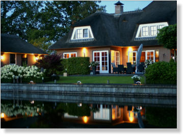 Woning aan het water, met verlichte steiger. Watervilla. Tuinverlichting. Led bolders.